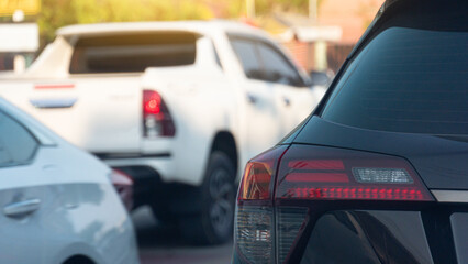 Close-up rear side of tail light of black car. Car driving queueing on the street. Cars were driving back and forth on the road.