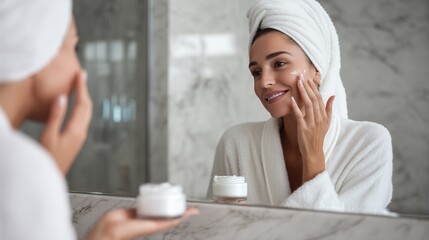 Woman examining her face in mirror while applying tallow cream, one hand touching smooth skin, satisfied expression, bright bathroom with good lighting, cream jar on marble counter