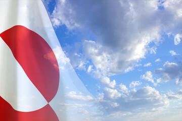 Flag of Greenland against the cloudy sky. National Holidays concept