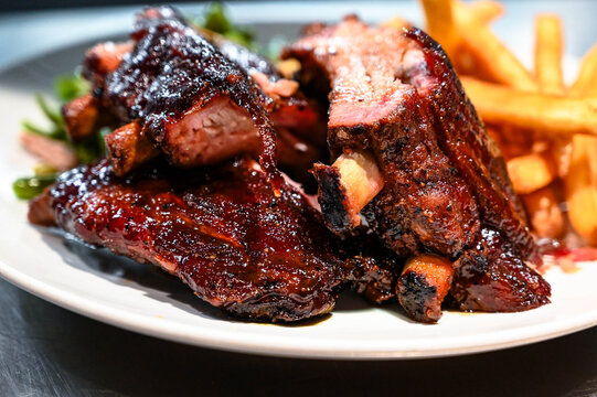 Platted smoked pork rib dinner with veggies and fries