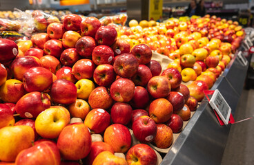 Close up of many red apples on shelf in supermarket store.
