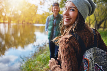 Woman, laughing and couple on hike, portrait and adventure with partner in nature, trekking and trip. Outdoor, hikers and people on journey in woods, backpacking and exploration on holiday or travel