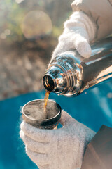 Coffee Pouring from Thermos into Cup on a Sunny Winter Day