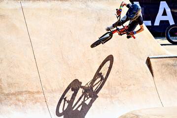 Obraz premium A young man practicing BMX and performing tricks at the skatepark.