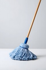 Blue string mop with wooden handle on a clean white background