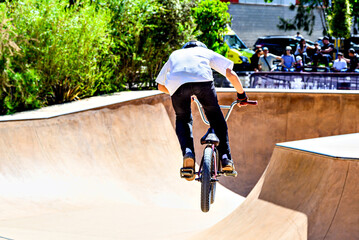 Obraz premium A young man practicing BMX and performing tricks at the skatepark.