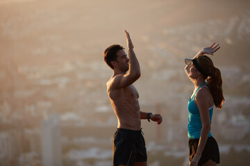 Fitness, high five and couple on mountain for exercise, workout goals and training together. Sports, morning and man with woman outdoor with success for challenge, active hobby and health in city