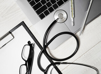 Health care concept. Stethoscope, laptop, glasses, thermometer and pen.
