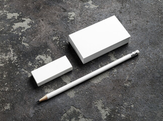 Photo of blank business cards, pencil and eraser on concrete surface. Stationery mockup. Template for ID.