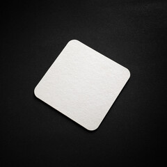 Blank square beer coaster mockup on black surface.