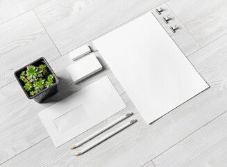 Blank corporate stationery set on light wooden surface. Responsive design mockup.