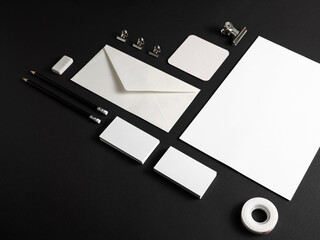 Blank stationery set on black paper surface. Template for branding identity for designers.