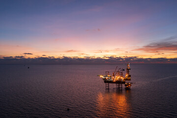 Obraz premium Aerial view of offshore jack up rig in a shipyard during sunset for oil and gas exploration and production.