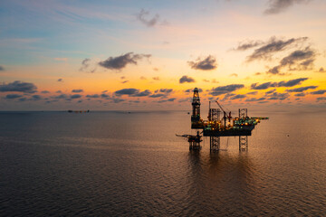 Aerial view from a drone of big jack up offshore drilling oil rig, production platform and supply...