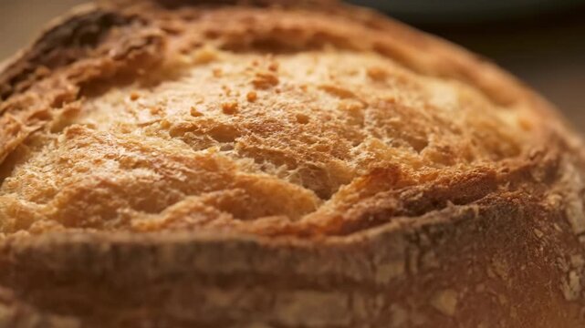 A close up view of a golden brown crusty bread with a porous texture This delicious food staple is ready to be enjoyed fresh from the oven