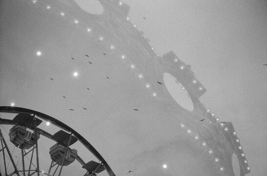 Double exposure film photo of carnival ride and birds