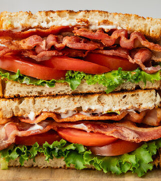Close up of layers of ingredients in stacked halves of a BLT sandwich.