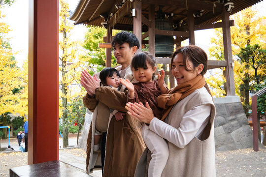 Family praying together at temple outdoors in Tokyo during autumn