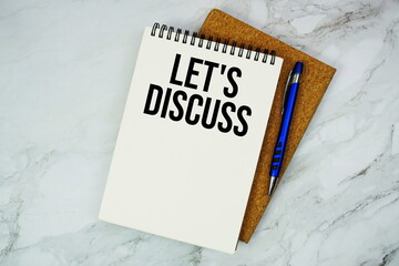 Let's Discuss text written on notepad with pen on marble background