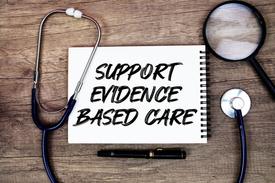 Support Evidence‑Based Care text written on notepad with stethoscope and magnifying glass on wooden background