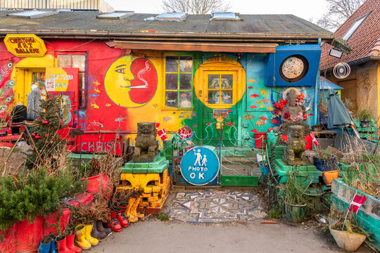 28 december 2025, Copenhagen, Denmark. Brightly colored houses in Freetown Christiania. An untended garden in front of the house. Various colors mixed together. Painted trash used as garden decoration