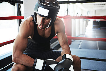 Thinking, athlete man and boxer in arena at gym for fitness, exercise and fight reflection. Male person, vision and gear in boxing ring for sports contest, match decision and solution for tournament