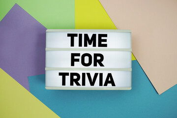 Time For Trivia text in lightbox flat lay on colorful pastel background