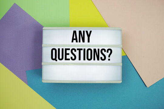 Any Questions? text in lightbox flat lay on colorful pastel background