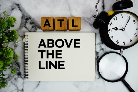 ATL Above The Line text with alarm clock and magnifying glass on marble background