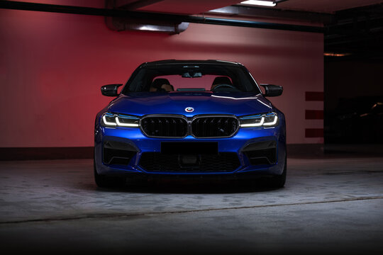 Blue BMW M5 high-performance luxury sedan parked in an indoor parking garage. Modern sports car with aggressive design, premium engineering, and dynamic presence. Concept of power, success, automotive