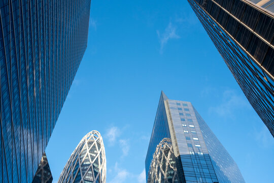 Skyward architecture skyscraper glass office corporate Paris La Defense blue geometry with strong perspective lines and minimal clouds above