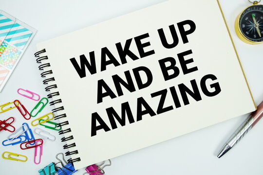 Wake Up and Be Amazing text message written on notepad with stationery flat lay on white background