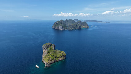 Obraz premium Beautiful Phi Phi Islands filmed from a drone, Bida Nok Island with Phi Phi Ley Island in the background, a high altitude view of the islands in Thailand.