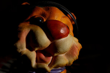 Bright toy figure tiger with a playful expression sitting in low light