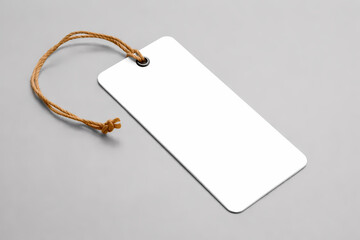 Blank white rectangular cardboard tag with brown string on gray background ready for design mockup or product labeling