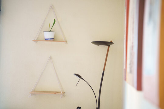 Minimalist cozy workspace, Elegant studio setup featuring hanging shelves and natural illumination