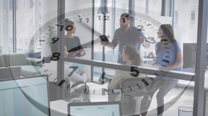 Animation of ticking clock against team of diverse colleagues discussing together at office - Powered by Adobe