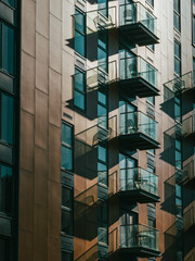 Modern apartment building facade with glass balconies and strong shadows © Bernd Brueggemann