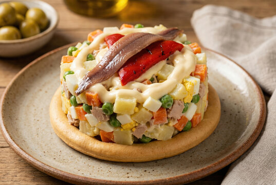 Presentaci&oacute;n de marinera servida sobre una rega&ntilde;&aacute; gigante con mayonesa, pimiento del piquillo y anchoa en un entorno r&uacute;stico