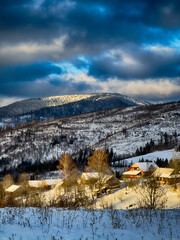 Mystical snowy Carpathian peaks under cloudy skies in the sunny weather