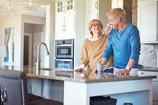 Laughing, coffee and love with old couple in kitchen in home for morning, bonding or wellness drink. Connection, beverage and drinking tea with senior man and woman in house for joke and commitment