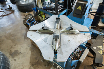 Close-up top view of dirty metal turntable clamping jaws of tire changer machine in auto repair...