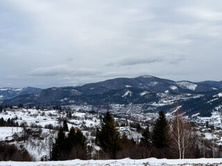 Mystical snowy Carpathian peaks under cloudy skies
