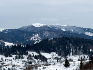 Mystical snowy Carpathian peaks under cloudy skies