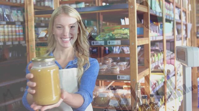 Animation of data processing over happy caucasian female shopkeeper holding jar of honey in shop