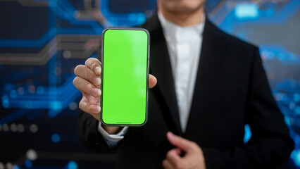 Asian business professional holding smartphone with green screen against futuristic digital background, information technology, mobile innovation, data driven strategy, fintech solutions