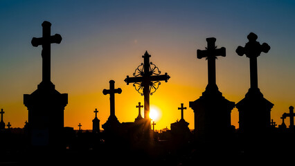 Silhouette of celtic crosses at sunset
