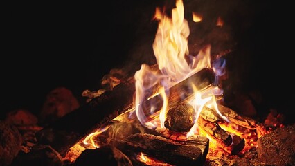 Slow motion seamless loop of a cozy campfire with glowing logs and dancing flames. Perfect loopable fire background.