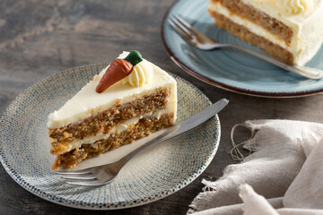 Carrot cake slice with cream cheese frosting on wooden table