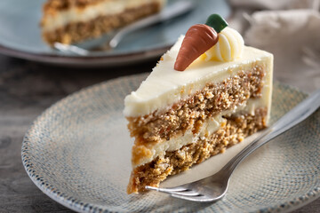 Carrot cake slice with cream cheese frosting on wooden table